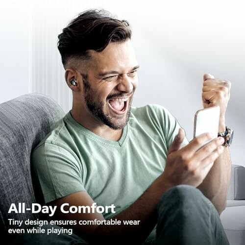 Man smiling with earbuds, looking at phone